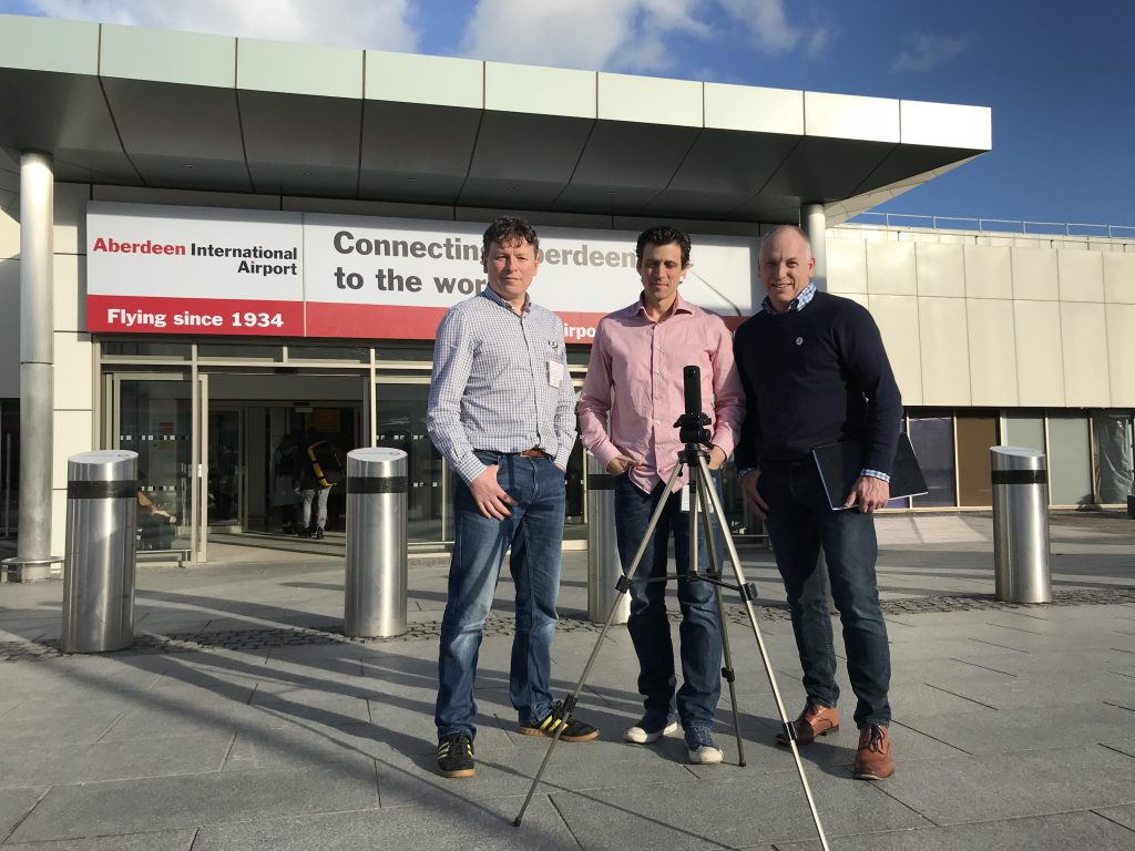 3 men standing outside Aberdeen Airport